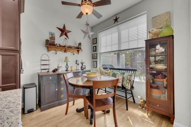 dining space with a ceiling fan and light wood finished floors