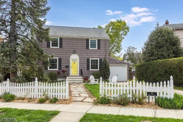colonial inspired home featuring fence and a garage