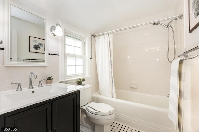 bathroom with shower / bathtub combination with curtain, toilet, and vanity