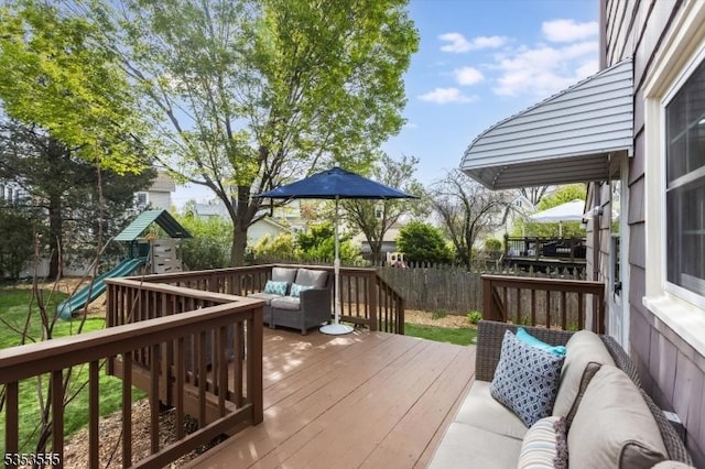 wooden terrace with a playground, outdoor lounge area, and a fenced backyard