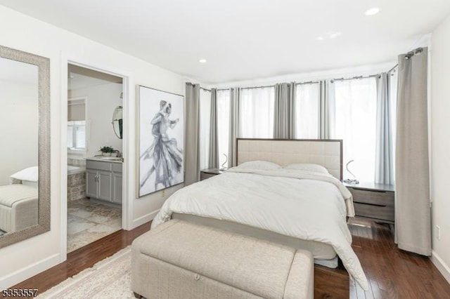 bedroom featuring recessed lighting, baseboards, wood finished floors, and ensuite bath