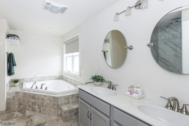 full bath with visible vents, a sink, a garden tub, and double vanity