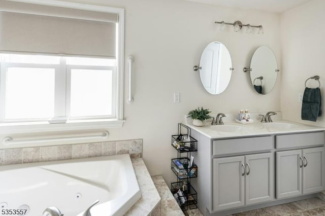 full bathroom with a jetted tub, a sink, and double vanity
