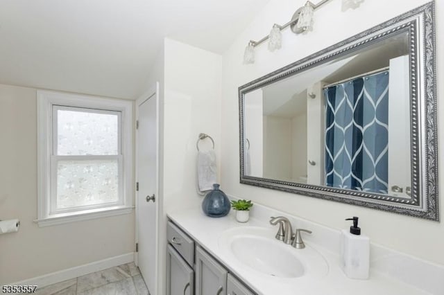 full bathroom featuring baseboards, marble finish floor, and vanity