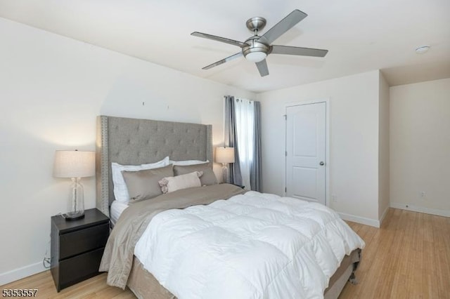 bedroom featuring baseboards, ceiling fan, and light wood finished floors