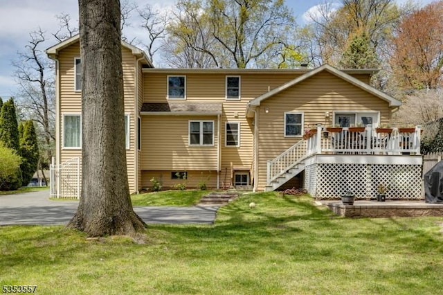 back of property with a lawn, stairway, and a wooden deck