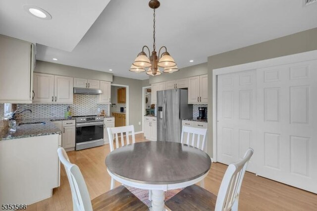 dining area featuring a chandelier, recessed lighting, and light wood finished floors