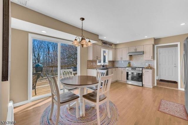 dining room featuring light wood finished floors, recessed lighting, an inviting chandelier, and a baseboard radiator