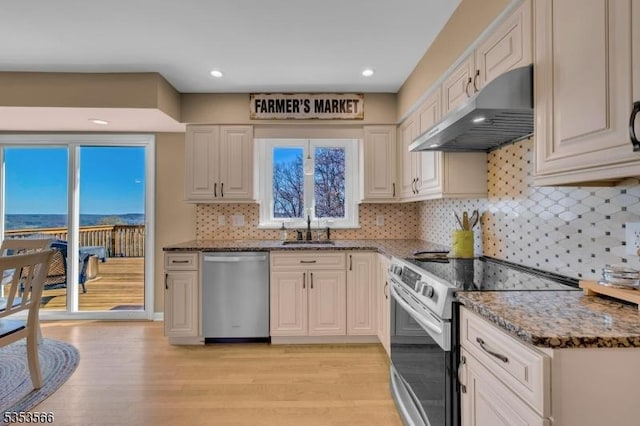 kitchen with a sink, stone countertops, under cabinet range hood, electric range, and dishwasher