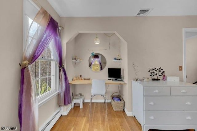 bedroom featuring baseboard heating, visible vents, light wood-style floors, and baseboards