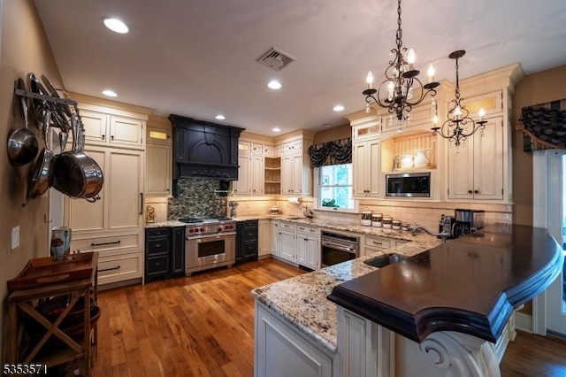 2 Natale Dr, Sparta Twp, NJ 07871 - kitchen featuring an inviting chandelier, a peninsula, custom exhaust hood, a sink, and appliances with stainless steel finishes