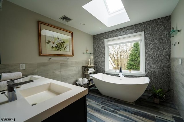 2 Natale Dr, Sparta Twp, NJ 07871 - full bathroom featuring a sink, a freestanding tub, tile walls, a skylight, and visible vents