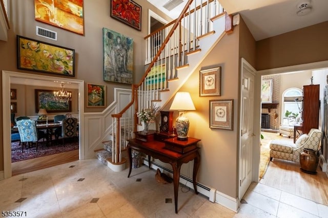 2 Natale Dr, Sparta Twp, NJ 07871 - stairs with a notable chandelier, baseboard heating, tile patterned flooring, a fireplace, and visible vents