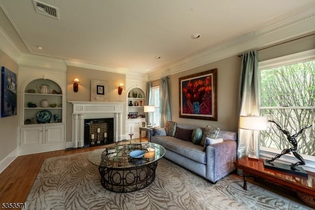2 Natale Dr, Sparta Twp, NJ 07871 - living room featuring visible vents, crown molding, a fireplace, wood finished floors, and built in shelves