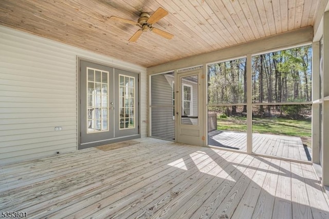 unfurnished sunroom featuring a ceiling fan and french doors
