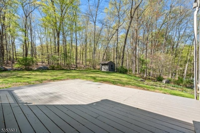 wooden deck featuring a storage shed, an outdoor structure, and a lawn