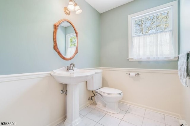 bathroom with tile patterned flooring, baseboards, and toilet