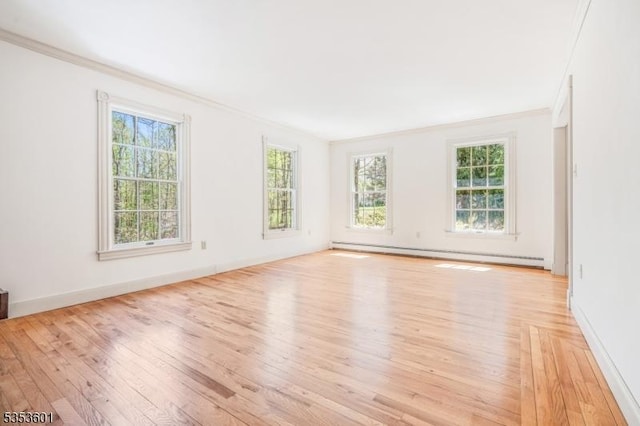 unfurnished room featuring crown molding, light wood-type flooring, a healthy amount of sunlight, and a baseboard radiator