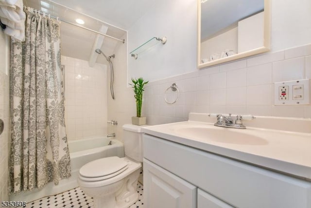 full bath with vanity, shower / tub combo with curtain, tile patterned flooring, toilet, and tile walls