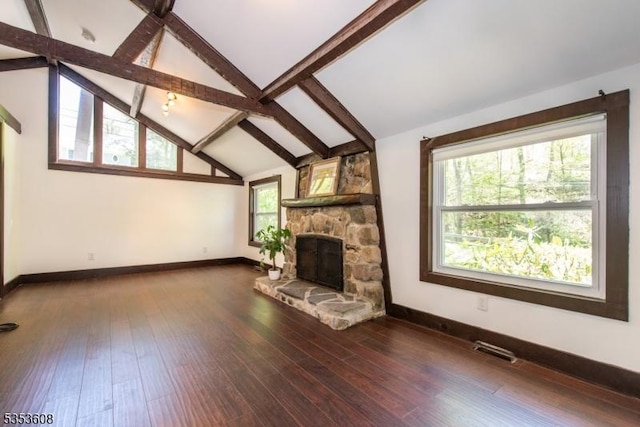 unfurnished living room with baseboards, vaulted ceiling with beams, a fireplace, and visible vents