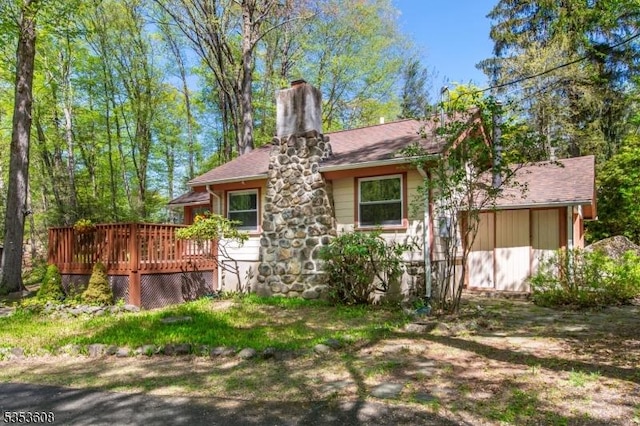 back of property featuring a chimney and a deck