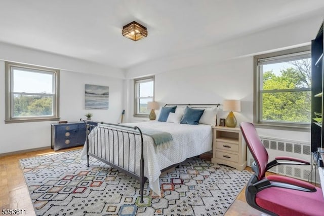 bedroom with baseboards and radiator