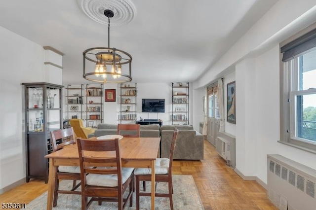 dining area featuring a notable chandelier, a healthy amount of sunlight, and radiator