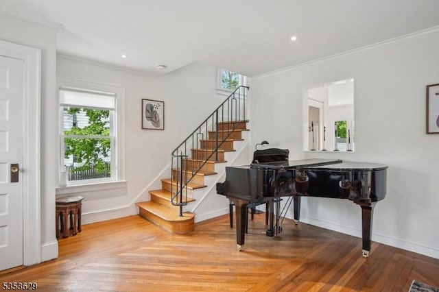 sitting room with stairs, crown molding, and a healthy amount of sunlight
