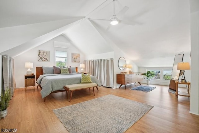 bedroom with multiple windows, wood finished floors, and lofted ceiling
