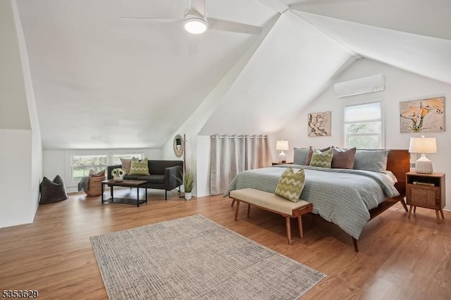 bedroom featuring vaulted ceiling, multiple windows, wood finished floors, and a wall unit AC