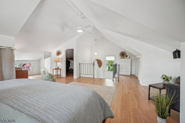 bedroom featuring ceiling fan, light wood-style flooring, and lofted ceiling