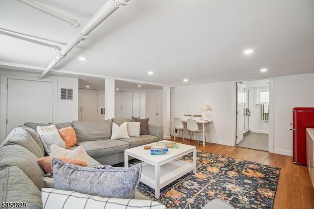 living room with baseboards, recessed lighting, light wood-style flooring, and visible vents