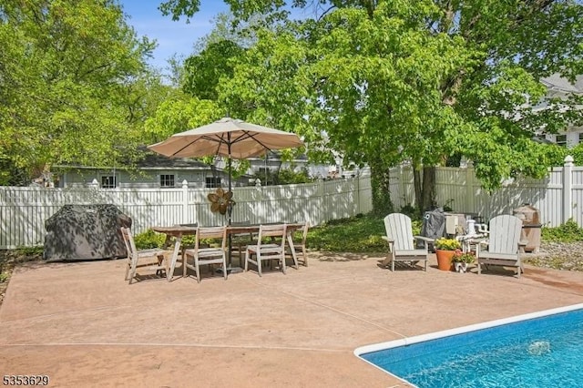 view of patio / terrace featuring fence, outdoor dining space, and a fenced in pool