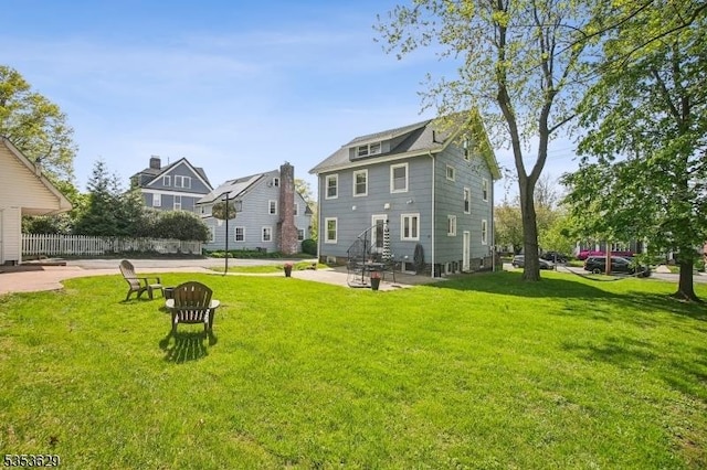 rear view of house featuring a lawn, a patio, fence, and entry steps