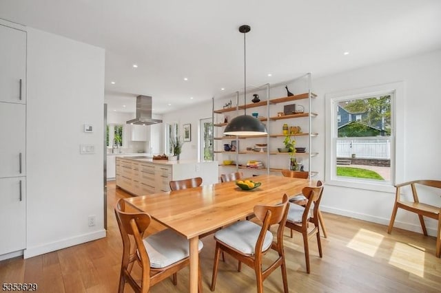 dining space with baseboards, recessed lighting, and light wood finished floors