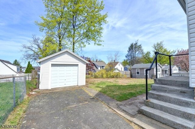 exterior space featuring fence, a residential view, and aphalt driveway