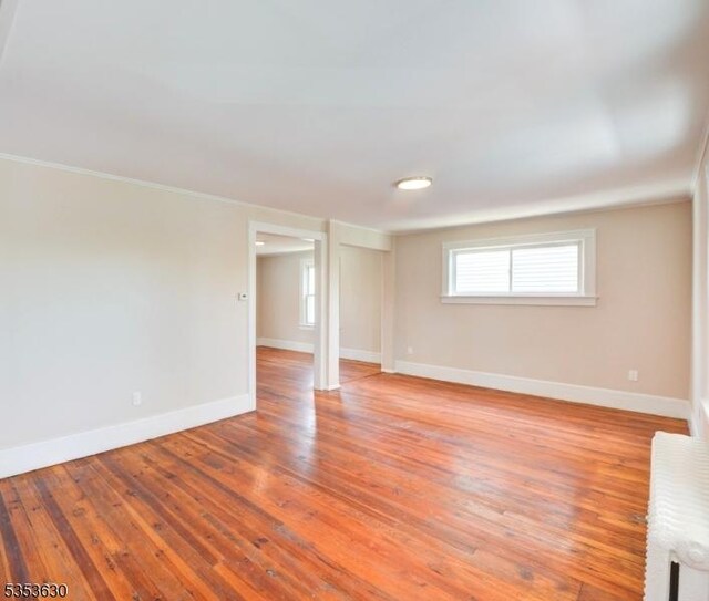 interior space featuring crown molding, baseboards, and light wood finished floors