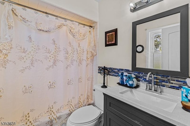 bathroom featuring tasteful backsplash, toilet, and vanity