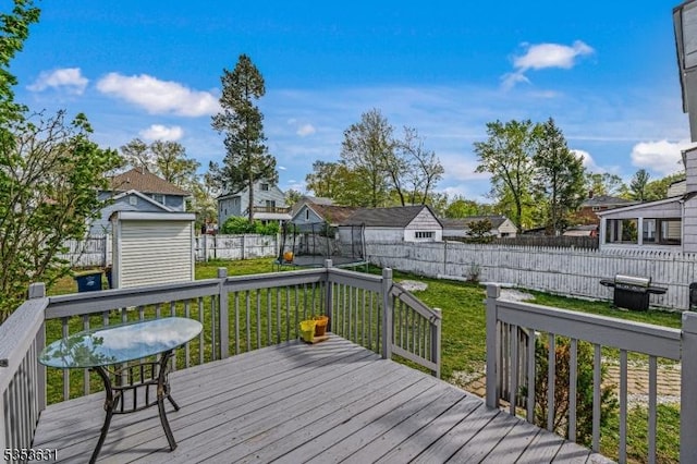 deck with a fenced backyard, a shed, and a yard