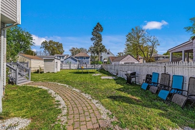 view of yard with a fenced backyard, a shed, an outbuilding, and a residential view
