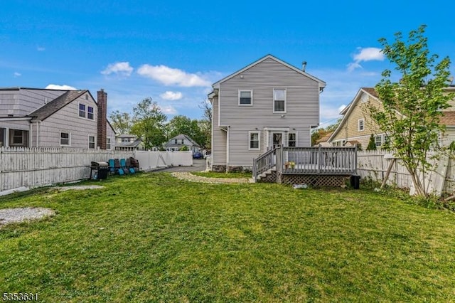 back of property featuring a fenced backyard, a yard, and a deck