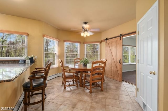 dining space with baseboards, a barn door, ceiling fan, and baseboard heating