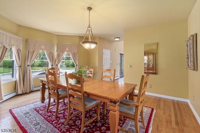 dining area featuring baseboards and light wood-style flooring