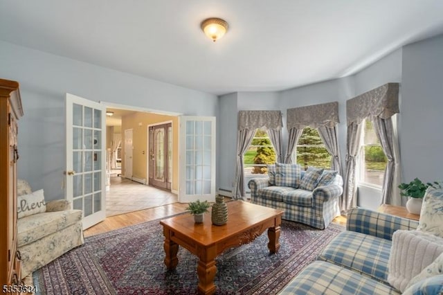 living room with french doors, light wood-style floors, and baseboards