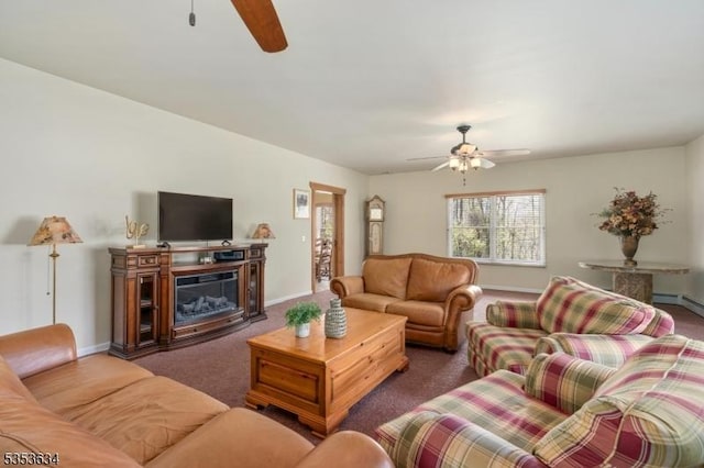 living area featuring a glass covered fireplace, baseboards, carpet, and a ceiling fan