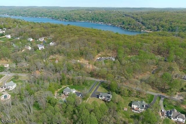 drone / aerial view featuring a water view and a wooded view