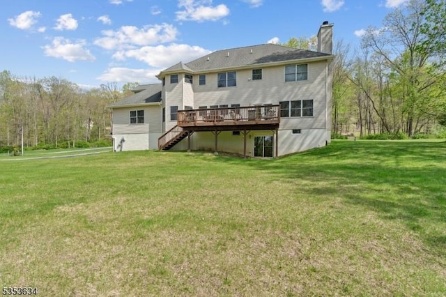 rear view of property with a lawn, a wooden deck, stairs, and a chimney