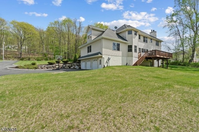 view of property exterior featuring a chimney, a wooden deck, a garage, stairway, and a yard