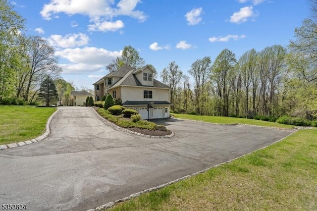 exterior space with a lawn, an attached garage, and driveway