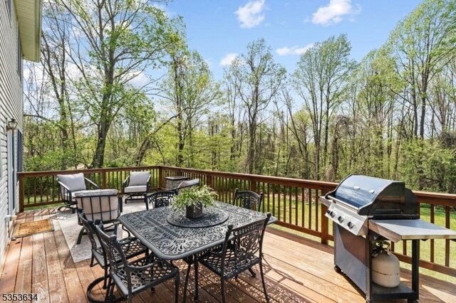 deck with outdoor dining area and a grill